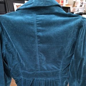 Green velvet blazer. Cinched back with pleats.